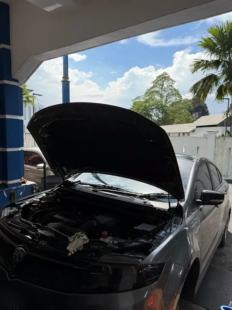 Grey sedan with its bonnet raised under the open-air bay canopy